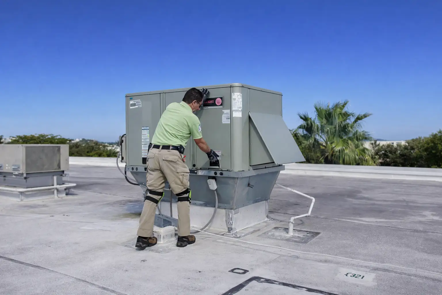Home inspector assessing a rooftop HVAC system during a commercial property inspection in Miami-Dade.