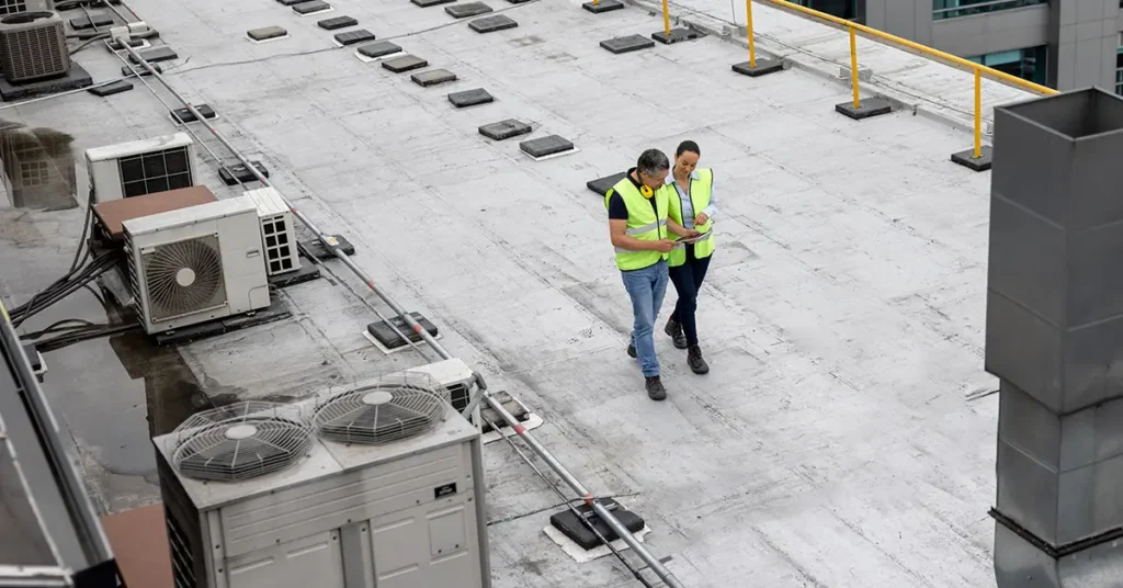 Inspector performing a commercial inspection on the roof of a commercial property after storm damage